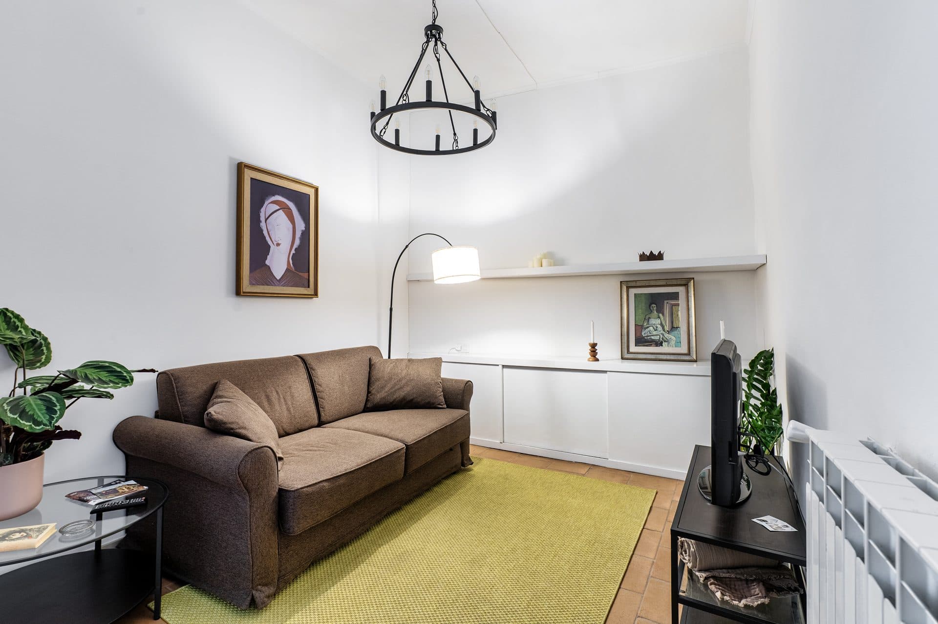 Il soggiorno con il divano e il lampadario in ferro battuto